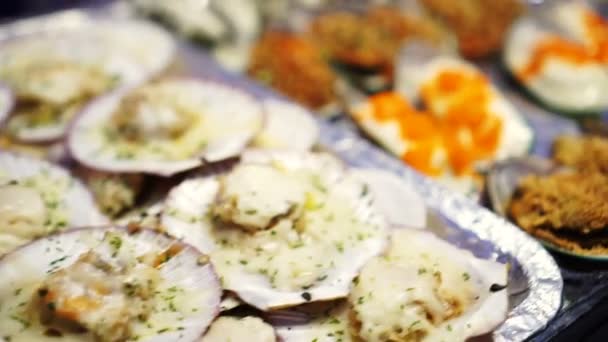 新鲜扇贝和贻贝与奶酪和其他顶在鱼市场街头食品烧烤 — 图库视频影像