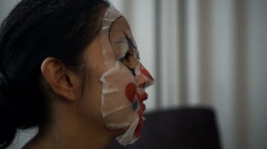Asyalı kadın giyen yüz bozo maskesini Cadılar Bayramı psikopat palyaço kız