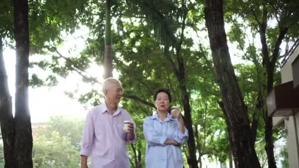 Feliz Asiático Casal Idosos Manhã Passeio Verde Cidade Enquanto Bebe — Vídeo de Stock