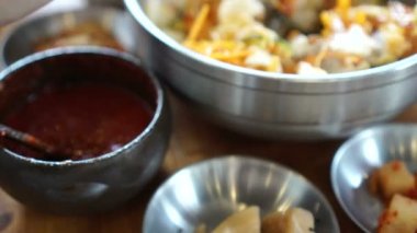 Çubuk ve bibimbap Kore ikonik yiyecek çanak karıştırma kaşık kullanarak ele