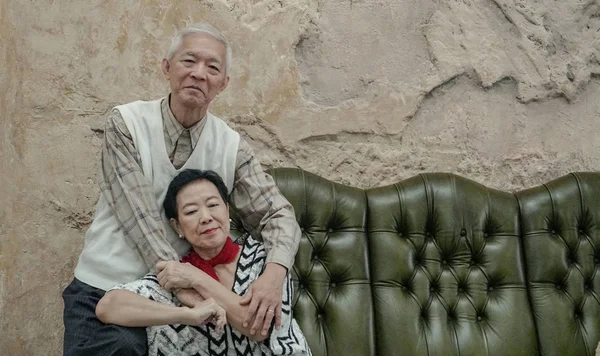 Wealthy Asian elderly couple happy hugging in luxury house