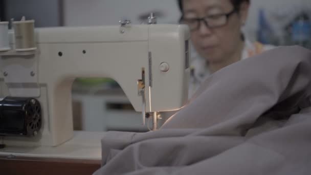 老亚洲母亲使用缝纫机修理紧致衣服4K — 图库视频影像