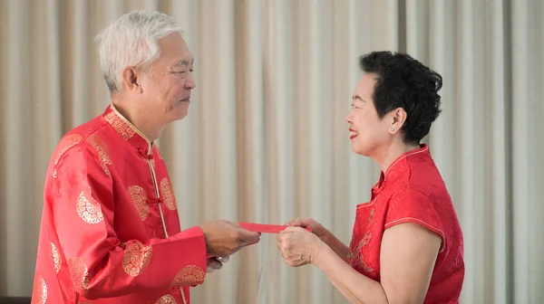 Aziatische Chinese senior paar Nieuwjaar rood omhullen gelukkig festival — Stockfoto