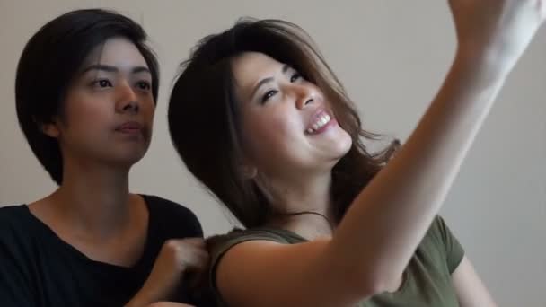 两个混合种族亚洲朋友使用智能手机 — 图库视频影像