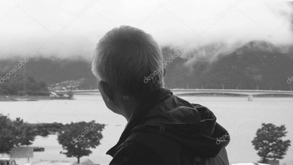 Lonely Asian senior man looking at view alone