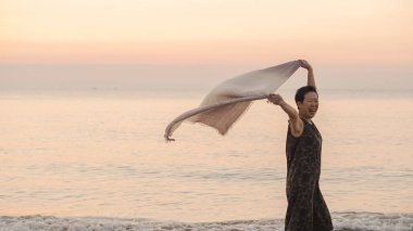 Atkı kumaş ve kopya ile plajda Mutlu Asya yaşlı kadın tun