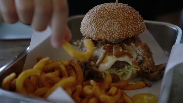 Mão Comendo Batatas Fritas Encaracoladas Hambúrguer Carne Com Cebola — Vídeo de Stock