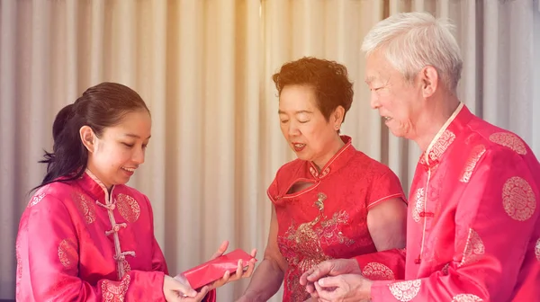 Asiatiska föräldrar ger röda omge till dotter kinesiska nyåret — Stockfoto