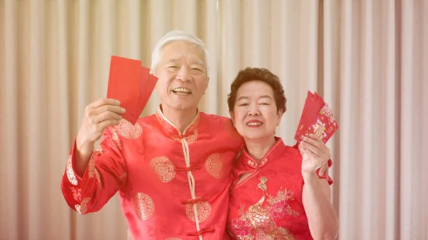 Aziatische Senior paar vieren Chinees Nieuwjaar in rode volmondig — Stockfoto