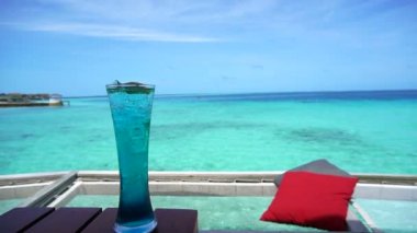 Mavi Hawaii kokteyl ve Maldivler deniz bar okyanus lüks yaşam tarzı üzerinde net koltukta kırmızı yastık