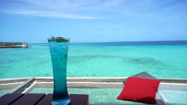 蓝色夏威夷鸡尾酒和马尔代夫海酒吧红色枕头在净座位的海洋豪华生活方式 — 图库视频影像