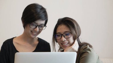 Karışık ırk Asyalı kızlar iş başlatmak için bilgisayar kullanarak