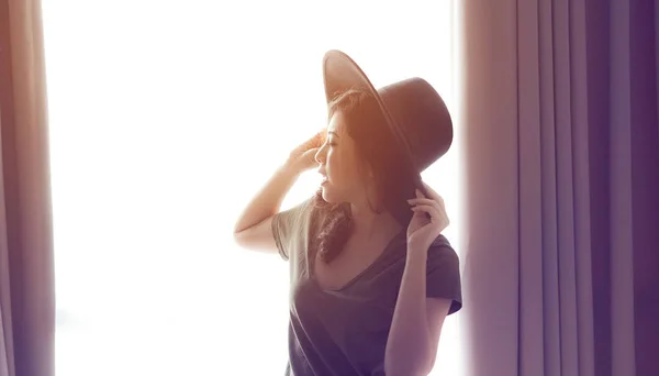 Asiatische Mixed Race Frau lange Haare tragen Hut nach Hause Vorhang Licht gewinnen — Stockfoto