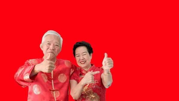 Starší asijský pár oslavují čínský Nový rok v červeném tradicenci — Stock fotografie