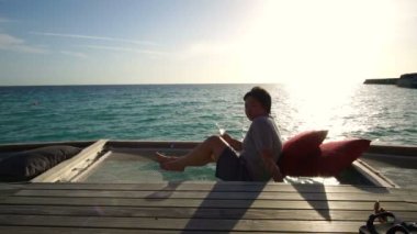 Zengin şişman Asyalı kadın Maldive lüks tatil günbatımı ve kokteyl rahatlatıcı