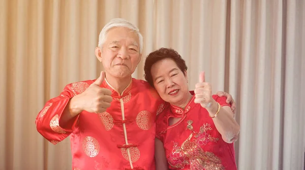 Asian senior couple celebrate Chinese new year in red traditiona — Stock Photo, Image