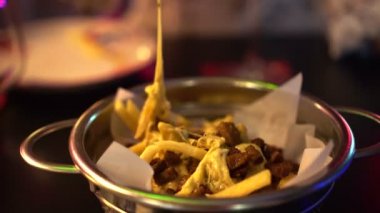 Kırmızı neon gece kulübünde peynirli patates yemek