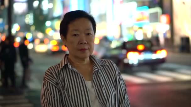 亚洲老年妇女在日本模糊夜光背景探索世界 — 图库视频影像