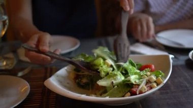 Sezar salatası karıya vermek için kaseye karışıyor.
