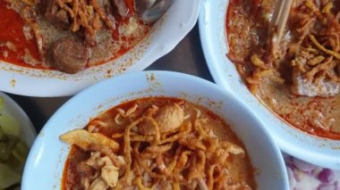 Kuzey Tayland yemeği yiyen eller Khao soi Hint cevizli kırmızı hindistan cevizli sütlü şehriye otlu şehriye