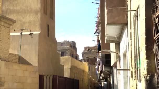 カイロエジプトエジプト建築居住区太陽の下で布をぶら下げ狭い路地 — ストック動画