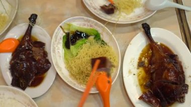 Erişteli kazlar Hong Kong yemeklerini birlikte yiyorlar.
