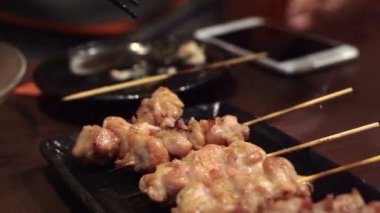 Japon izakaya yakitori ızgara tavuk yiyor.