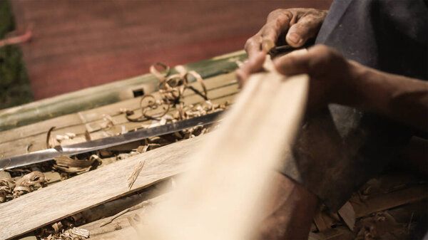 Elder man hand use knife cutting and shape bamboo craftman work in Thailand