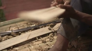 Yaşlı adam Tayland 'da bambu işçiliği yaparken bıçak kullanıyor.