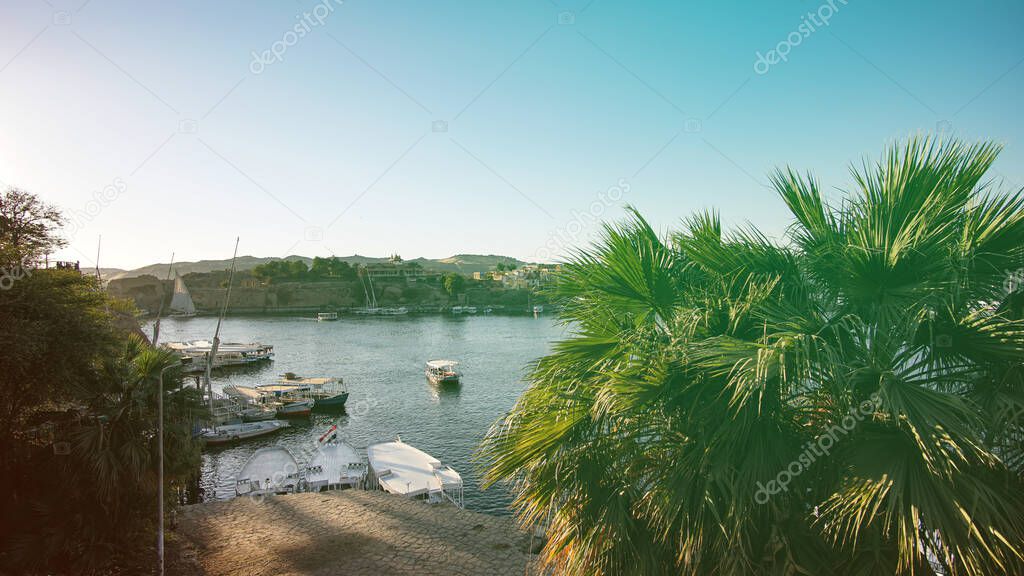 Egypt Nile river port of Aswan river view of architecture local life palm trees and felucca boats