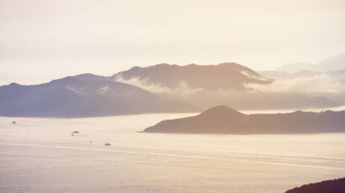 Hong Kong okyanusu, günbatımı, dağ cenneti arka plan, denizcilik gemisi kargo gemisi sanayii.