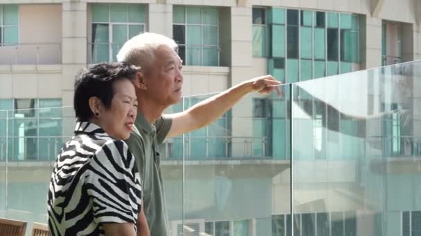 バンコクのスカイラインを見下ろす超高層ビルの屋上にアジアの高齢者のカップル — ストック動画