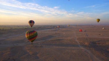 Kral Unesco mirası bölgesinin Luxor Mısır vadisinde sıcak hava balonuna binen hava hareketi güneş doğuyor.