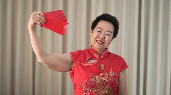 快乐的亚洲老年妇女中国农历新年红包着传统服装 — 图库照片