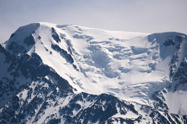 High mountain peaks covered with white shining snow. North-Chuya Range, the Republic of Altai.