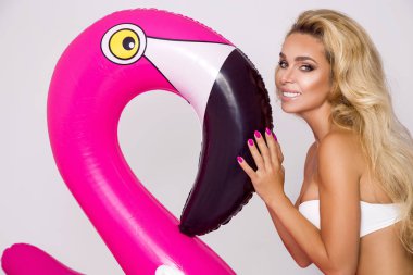 Güzel seksi sarışın model pembe flamingo ile zarif bir bikini. Yaz vurmak