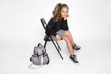 Güzel, küçük bir kız okul kıyafetleri ve okul sırt çantası, giymiş Studio teşkil etmektedir. Okula dönüş.