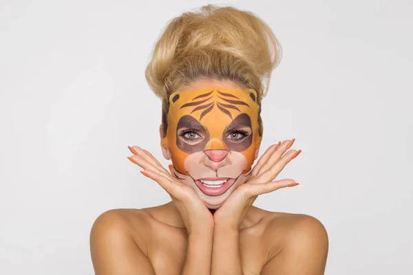 Beautiful woman with moisturizing leopard face mask. Mask with leopard, cat.