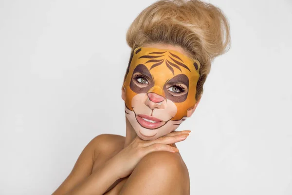 Beautiful woman with moisturizing leopard face mask. Mask with leopard, cat.