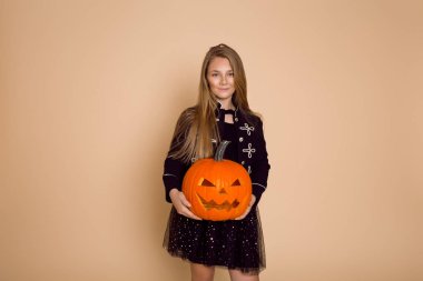 Cadılar Bayramı kıyafeti stüdyoda güzel genç kız. Balkabağına tutan kız.