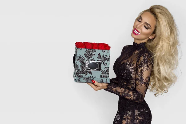 バラとプレゼント ボックスを保持してエレガントなドレスでセクシーな美しいブロンド モデル — ストック写真