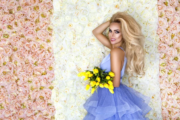 Fashion wedding dress model with a bouquet of tulips. Beautiful bride model in blue amazing wedding dress. Beauty young woman on the background of flowers - Image