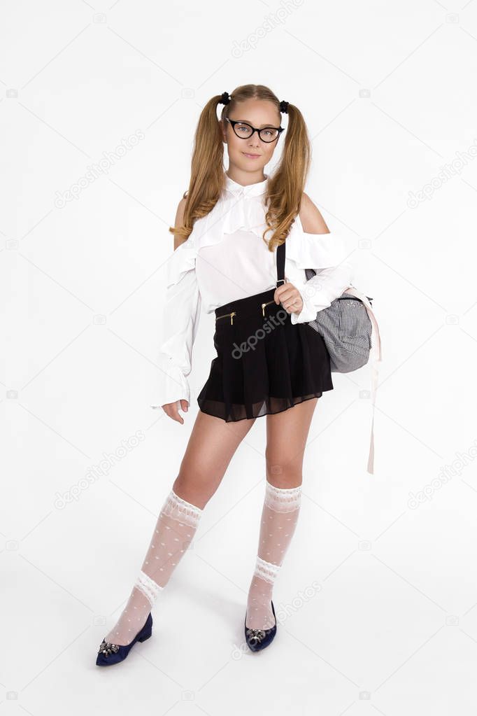 Girlish cute cheerful lovely stylish little girl with curly ponytails in formal blouse shirt, short black skirt. Isolated over white background. Back to school - Image