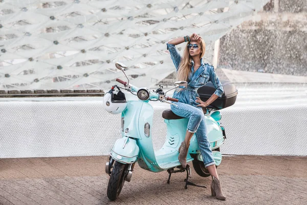 Sexy young woman riding on motorbike in street, summer vacation style, traveling,stylish outfit, adventures. Spring summer fashion model. Jeans fashion. Paris. Girl on a scooter in jeans - Image