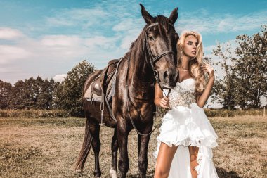 Siyah bir at ve kadının portresi. Atı olan güzel, çekici bir kadın. Gelinlik giymiş güzel sarışın bir gelinin portresi..