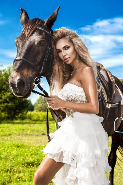 暗い馬と女性の肖像画 馬と美しい魅力的な女性 馬と結婚式のドレスで美しいブロンドの花嫁の肖像 — ストック写真
