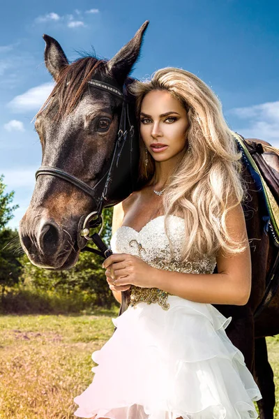暗い馬と女性の肖像画 馬と美しい魅力的な女性 馬と結婚式のドレスで美しいブロンドの花嫁の肖像 — ストック写真