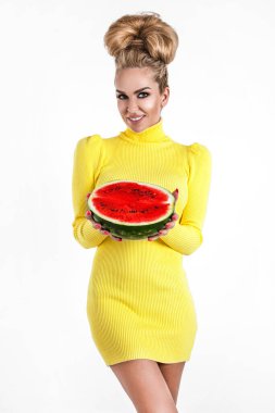 Beyaz arka planda izole edilmiş bir karpuz dilimini tutan renkli elbiseli mutlu genç kadın. Güzel manken karpuz tutar. Yaz modası.
