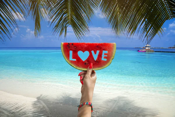 西瓜片与文字的爱 女人的手牵着它的蓝天和印度洋 夏天的概念 热带岛屿海滩 马尔代夫岛 — 图库照片