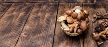 Orman hasırlı sepetten mantar topluyor. Üst görünüm fotokopi alanı. Masada taze çiğ mantar var. Tahta masadaki mantarlar..